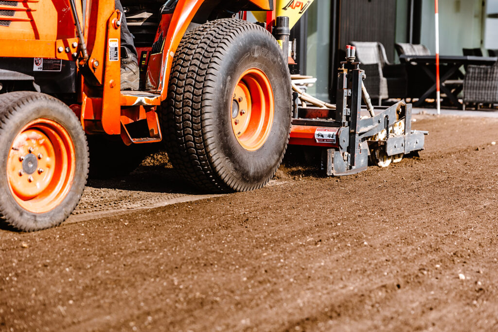 Auf dem eingeebneten Boden wird das Saatgut mit einer traktorbetriebenen Sämaschine ausgesät.